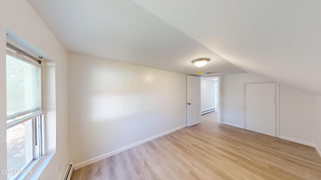 bonus room with light hardwood / wood-style floors, vaulted ceiling, and a baseboard heating unit