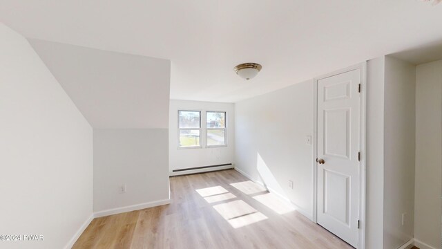 interior space with a baseboard radiator and light hardwood / wood-style floors