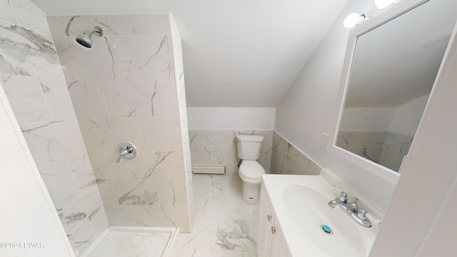 bathroom with vanity, toilet, a tile shower, and tile walls