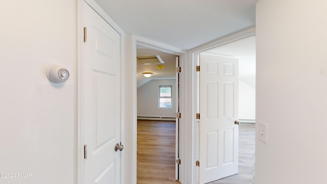 hallway with a baseboard radiator and light hardwood / wood-style floors