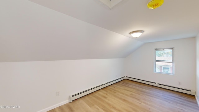 additional living space featuring light hardwood / wood-style floors and vaulted ceiling