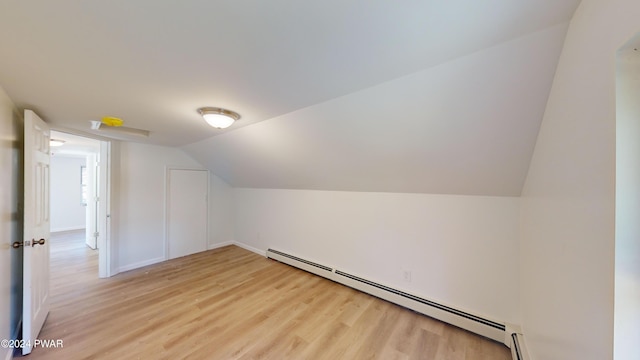 bonus room featuring light wood-type flooring, lofted ceiling, and a baseboard heating unit