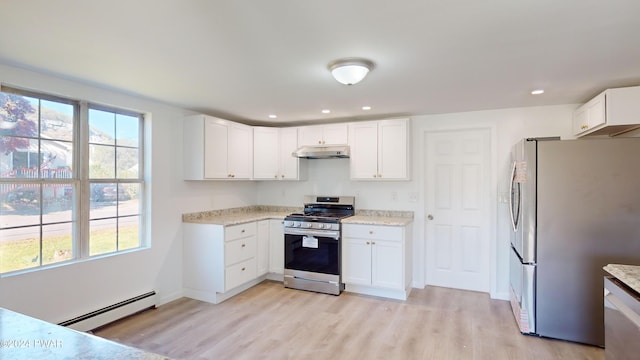 kitchen featuring a baseboard radiator, light stone counters, appliances with stainless steel finishes, white cabinets, and light wood-type flooring