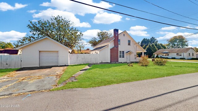 view of home's exterior featuring a yard, a garage, and an outdoor structure