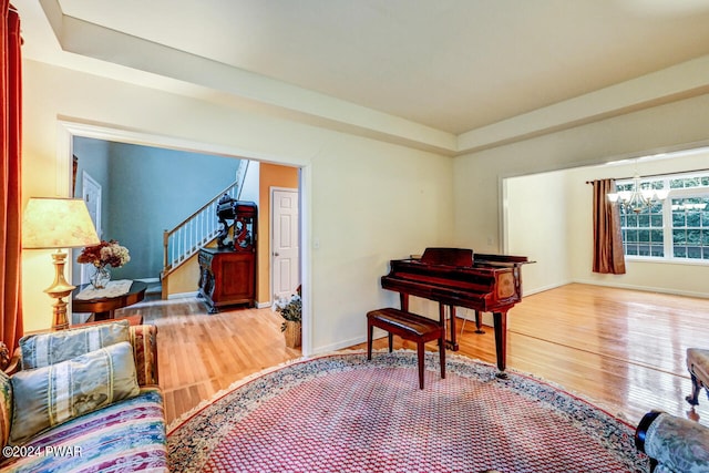 living area with wood-type flooring and an inviting chandelier