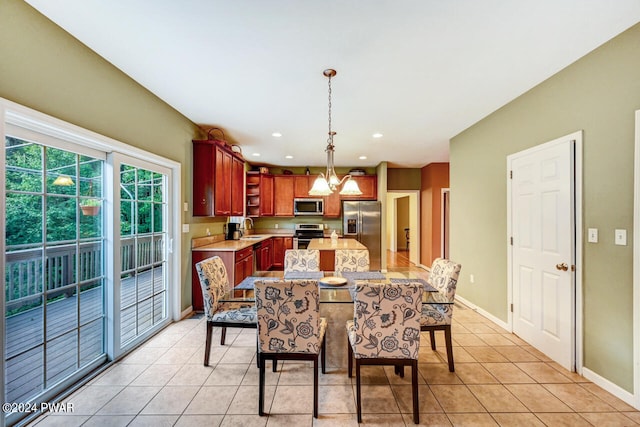 dining area with sink, light tile patterned floors, and a chandelier