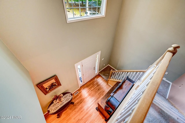 stairway with a high ceiling and wood-type flooring