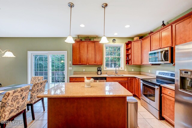 kitchen with pendant lighting, a center island, stainless steel appliances, and sink