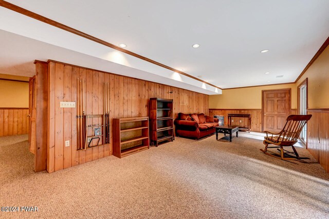 carpeted living room featuring crown molding and wood walls