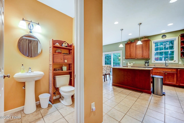 kitchen featuring sink, decorative light fixtures, and light tile patterned flooring