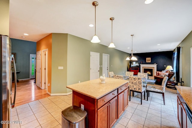 kitchen featuring stainless steel fridge, a center island, light tile patterned floors, and pendant lighting