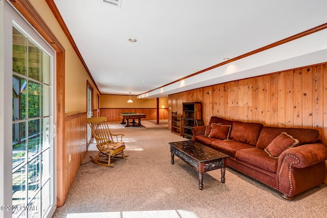 carpeted living room with crown molding and wood walls