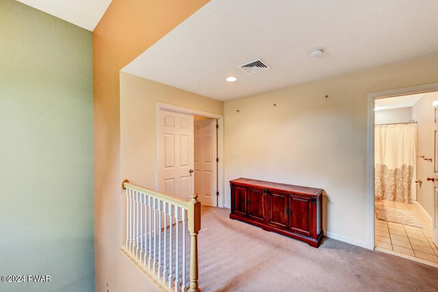 hall with light colored carpet