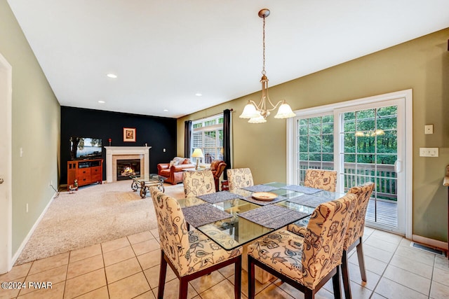 dining area with light carpet and a chandelier