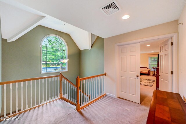 corridor featuring carpet flooring and lofted ceiling