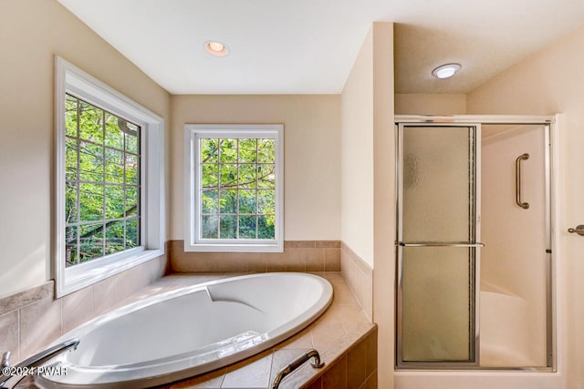 bathroom featuring plenty of natural light and separate shower and tub