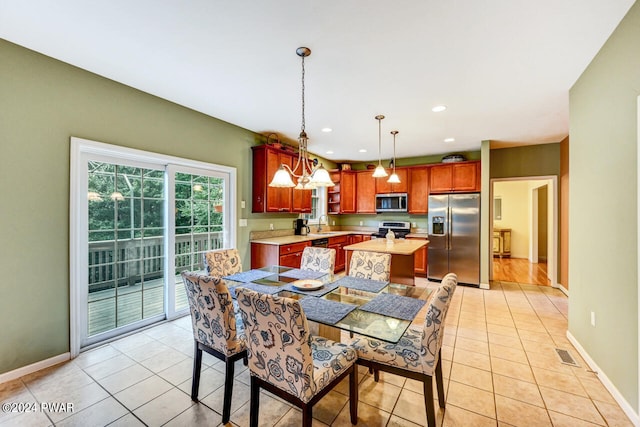 dining room with a notable chandelier, light tile patterned flooring, and sink