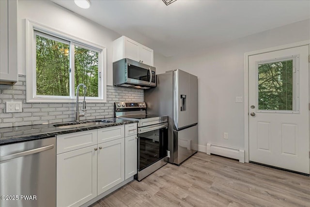 1180 Wallenpaupack Dr, Lake Ariel, PA 18436 - kitchen with stainless steel appliances, a baseboard radiator, white cabinetry, backsplash, and dark stone countertops