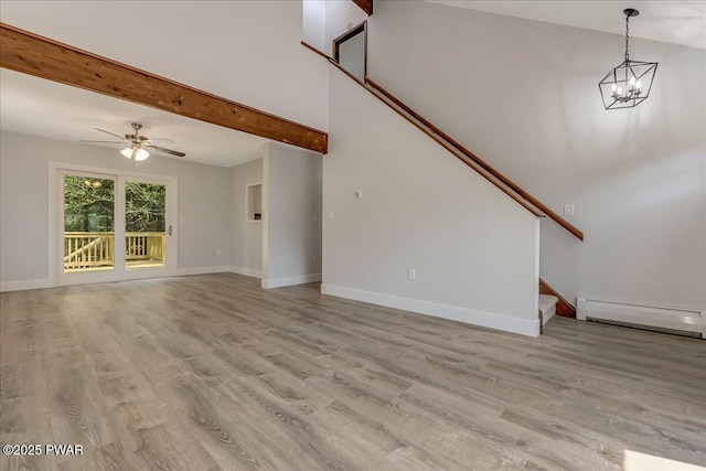1180 Wallenpaupack Dr, Lake Ariel, PA 18436 - unfurnished living room with baseboard heating, stairs, wood finished floors, beam ceiling, and a ceiling fan