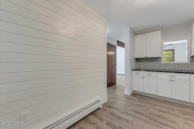 1180 Wallenpaupack Dr, Lake Ariel, PA 18436 - kitchen with baseboard heating, dark countertops, light wood-style flooring, and white cabinetry