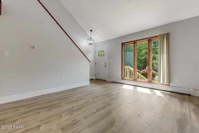 1180 Wallenpaupack Dr, Lake Ariel, PA 18436 - unfurnished living room with a baseboard heating unit, light wood-type flooring, lofted ceiling, and a chandelier
