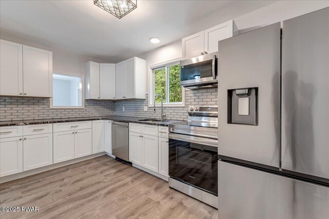 1180 Wallenpaupack Dr, Lake Ariel, PA 18436 - kitchen with appliances with stainless steel finishes, white cabinetry, decorative backsplash, and light wood finished floors
