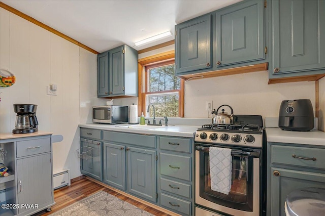 91 Bruin Rd, Lake Ariel, PA 18436 - kitchen with stainless steel appliances, a sink, light countertops, a baseboard radiator, and light wood finished floors