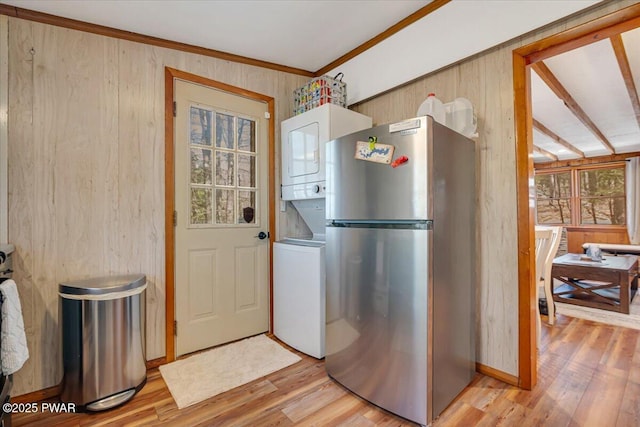 91 Bruin Rd, Lake Ariel, PA 18436 - kitchen with freestanding refrigerator, stacked washer and clothes dryer, wood walls, light wood finished floors, and ornamental molding