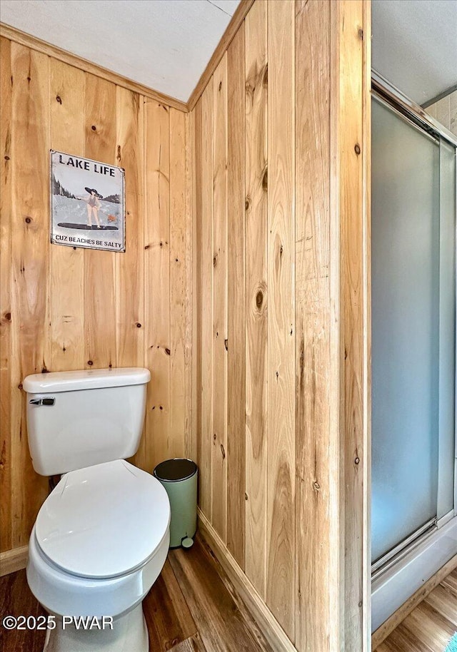 91 Bruin Rd, Lake Ariel, PA 18436 - bathroom featuring a shower stall, wood finished floors, toilet, baseboards, and wooden walls