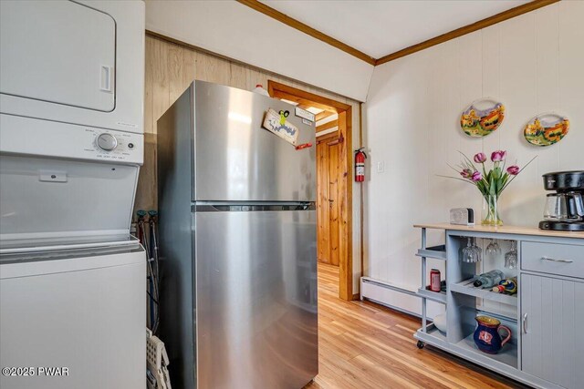 91 Bruin Rd, Lake Ariel, PA 18436 - kitchen featuring freestanding refrigerator, estacked washer and dryer, crown molding, baseboard heating, and light wood-type flooring