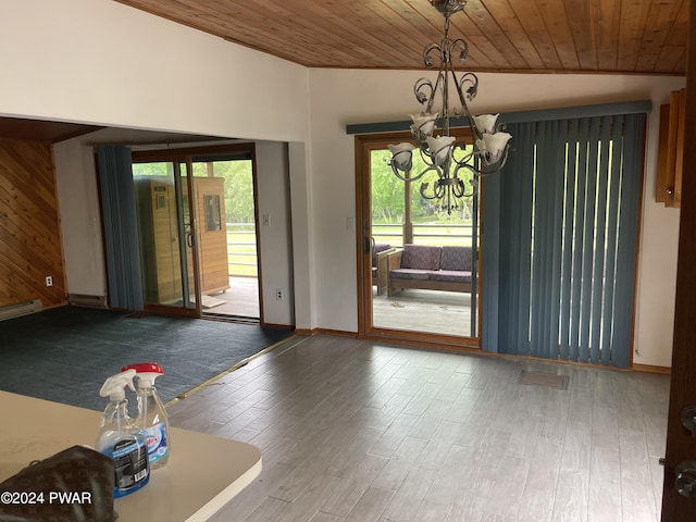 interior space featuring a chandelier, hardwood / wood-style floors, wooden ceiling, and wood walls