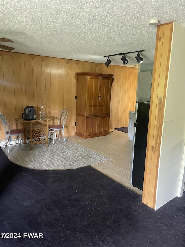 interior space with rail lighting, wooden walls, and light carpet