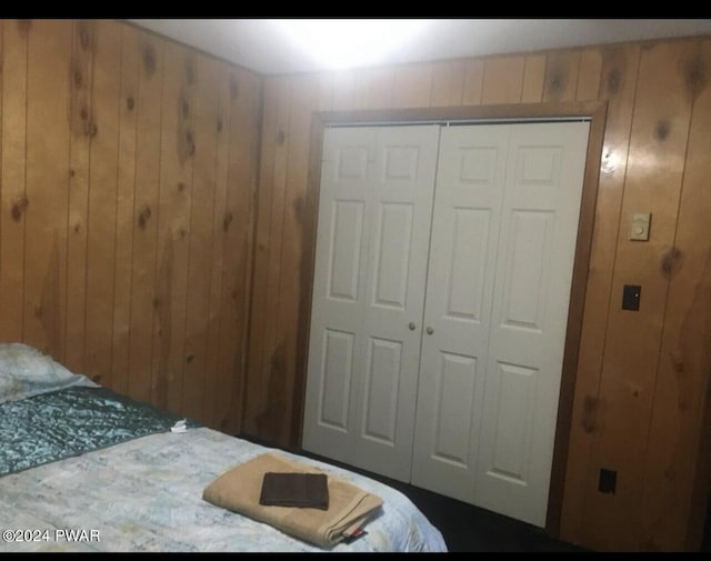 bedroom with wooden walls and a closet