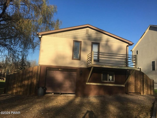 back of property with a garage and a balcony