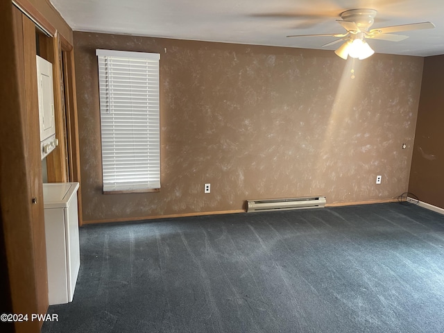 carpeted empty room featuring baseboard heating, ceiling fan, and stacked washing maching and dryer