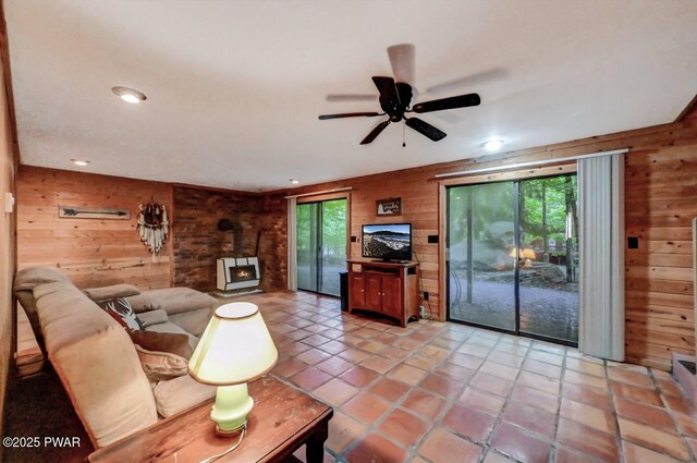 24 Lakewood Dr, Lake Ariel, PA 18436 - living area featuring wooden walls, a wood stove, ceiling fan, recessed lighting, and light tile patterned floors