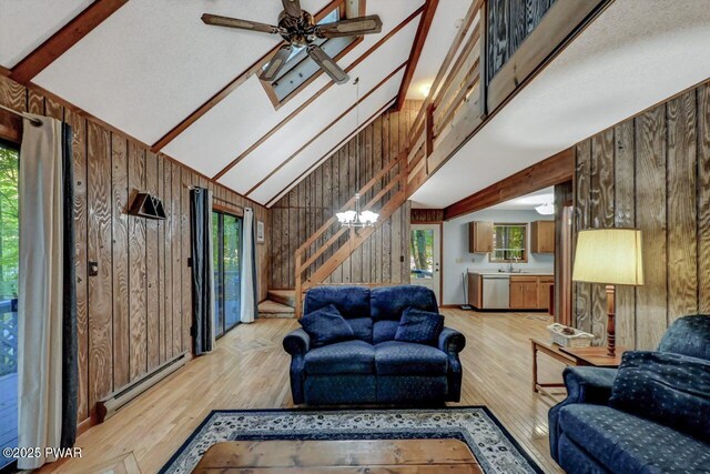 24 Lakewood Dr, Lake Ariel, PA 18436 - living area featuring wood walls, baseboard heating, stairs, high vaulted ceiling, and light wood-type flooring
