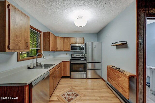 24 Lakewood Dr, Lake Ariel, PA 18436 - kitchen with stainless steel appliances, a sink, light wood-style floors, light countertops, and a textured ceiling
