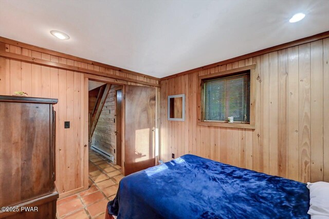 24 Lakewood Dr, Lake Ariel, PA 18436 - bedroom with a baseboard radiator, wooden walls, and light tile patterned floors