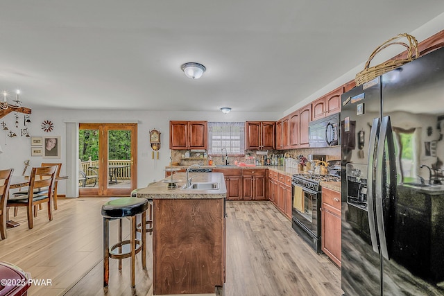 2106 Blueberry Ct, Bushkill, PA 18324 - kitchen featuring black appliances, healthy amount of natural light, decorative backsplash, and light wood finished floors