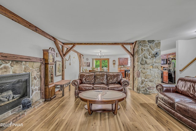 2106 Blueberry Ct, Bushkill, PA 18324 - living room with a stone fireplace, light wood-style flooring, and a chandelier