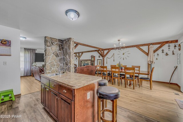 2106 Blueberry Ct, Bushkill, PA 18324 - kitchen featuring open floor plan, light countertops, a chandelier, a kitchen island with sink, and light wood finished floors