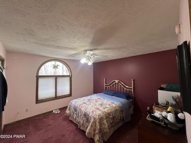 bedroom with ceiling fan, dark carpet, and a textured ceiling