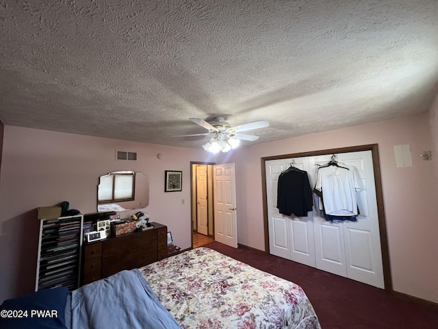 carpeted bedroom featuring ceiling fan, a textured ceiling, and a closet