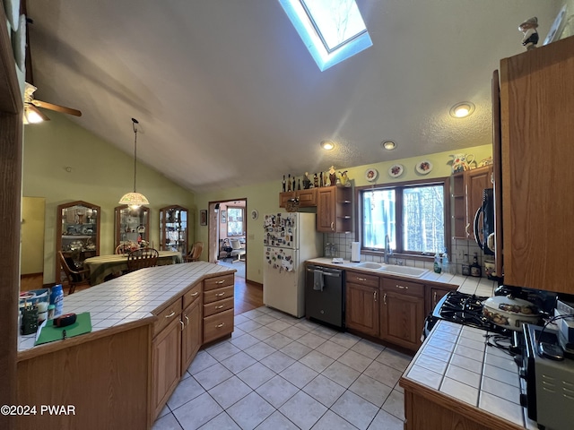 kitchen with backsplash, hanging light fixtures, tile counters, and black appliances