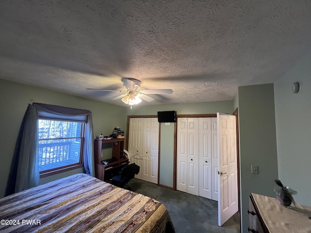 carpeted bedroom with two closets, ceiling fan, and a textured ceiling