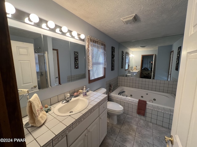 full bathroom with tile patterned flooring, a textured ceiling, shower with separate bathtub, toilet, and vanity