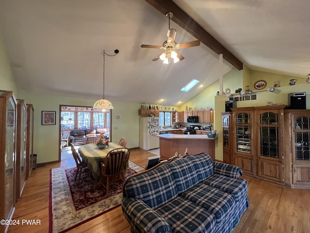 dining room featuring beamed ceiling, ceiling fan, light wood-type flooring, and high vaulted ceiling