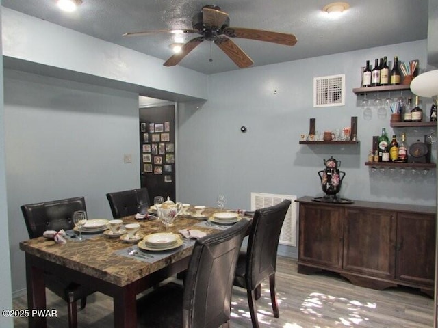 102 Yvonne Ct, Dingmans Ferry, PA 18328 - dining room featuring a bar, a ceiling fan, visible vents, and light wood-style flooring