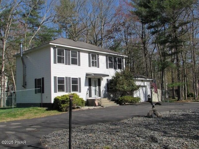 102 Yvonne Ct, Dingmans Ferry, PA 18328 - colonial house featuring a garage, aphalt driveway, and fence